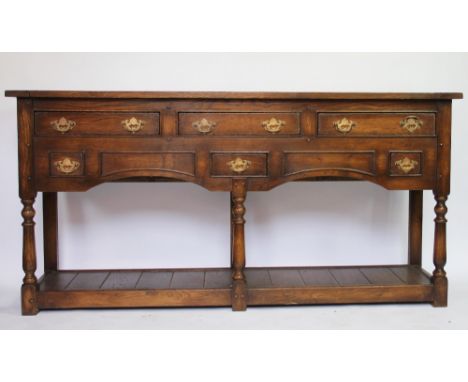 A George III style oak dresser base, with six drawers and pot shelf, on turned legs, 77cm H x 155cm W x 37cm D