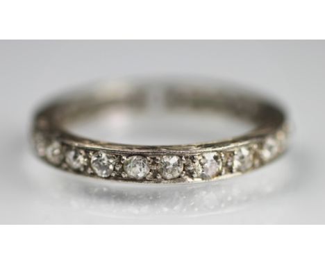 A diamond set full eternity ring, the twenty four diamonds within white metal setting and carved sides, stamped 'PLAT' (one s