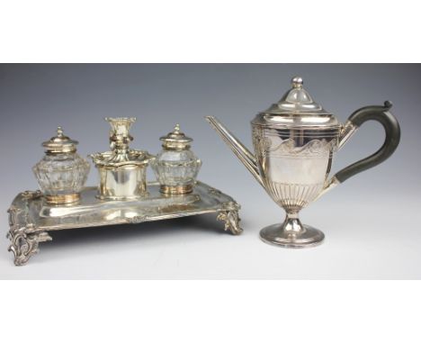 An old Sheffield plate desk stand, with a central chamber stick flanked by two inkwells, upon four cast scroll feet, 27cm wid