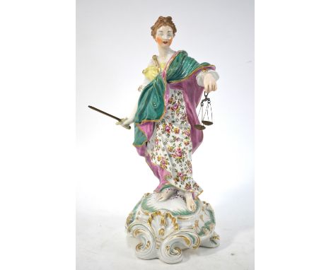 An 18th century Derby figure of Justice standing on a tall rococo scrolled base, her eyes closed to guarantee her impartialit