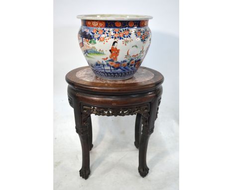 A Chinese wood stand with oval stone centre; together with a Japanese Imari planter, decorated with figures beside a shoji, o