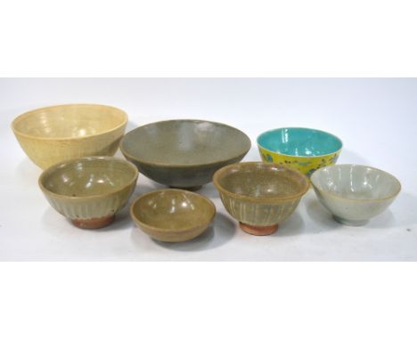 Seven Asian ceramic bowls or dishes, including: a yellow-ground, famille rose bowl with six-character Qianlong mark; two smal
