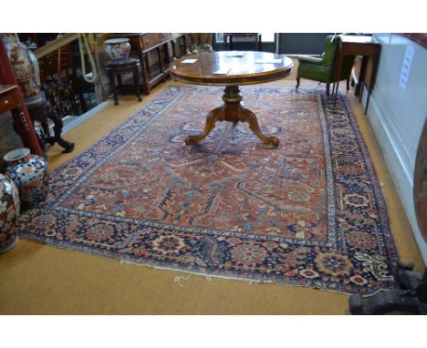 A Heriz carpet, North West Persia, circa 1930s, stylised floral design on terracotta ground within a guarded dark blue rosett