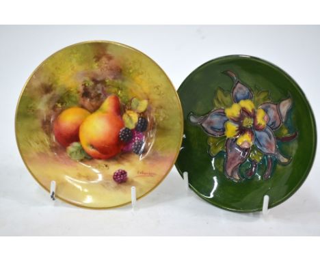A small Moorcroft bowl, green ground decorated with a clematis flower, bears paper label - 'Potters to the late Queen Mary', 