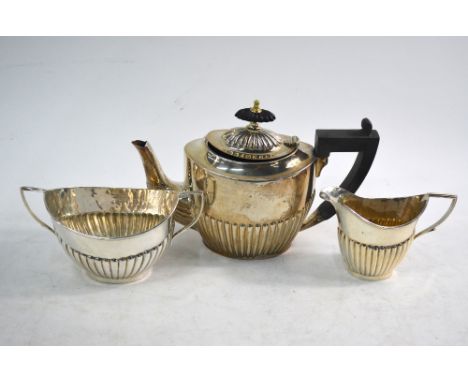 A matched silver three-piece half-reeded bachelor tea service, Birmingham 1895/1935, 12.5 oz gross   Condition Report  Teapot