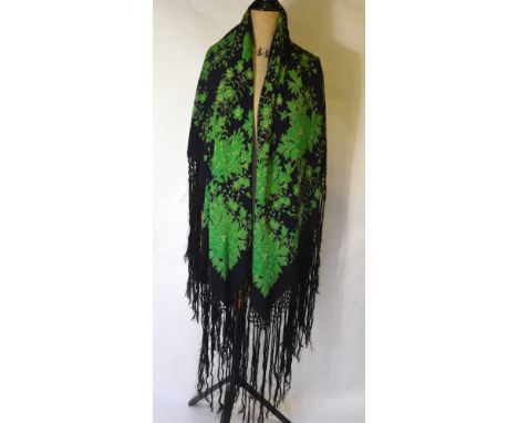 A Chinese dark blue silk fringed shawl printed with jade green flowering peony design, 130 cm x 140 cm (plus 43 cm fringing) 