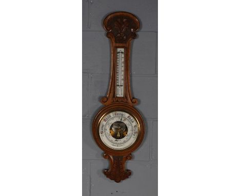 Early 20th Century golden oak cased aneroid barometer/ thermometer, the white dial with retailers name M. Heilbron 84 Bridge 