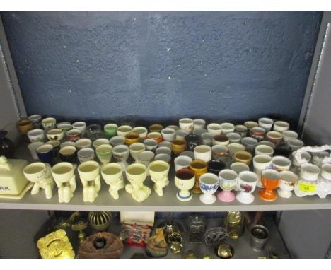 A large collection of egg cups to include Watcombe ware, Booths, Lurpack and a butter dish 