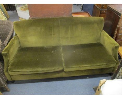 An Edwardian two-seater sofa upholstered in a green velour fabric on short ebonized square tapering legs with loose seat cush