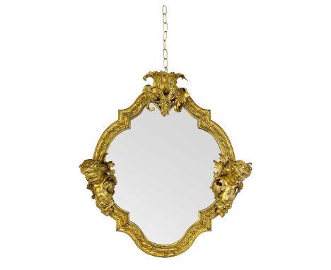 A substantial gilt bronze wall mirror. Probably French, 19th century, the cartouche shape frame with relief foliate cast deco
