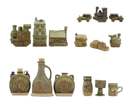 A large collection of Tremar pottery.  To include four money boxes, two moddeled as trains, one a tuckshop, and a manor house