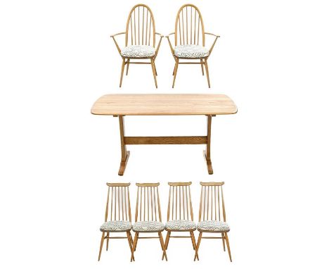An Ercol light elm and beech dining table and six chairs. Raised on trestle end supports and a stretcher, height 73cm, width 