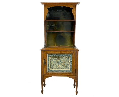 An Arts and Crafts oak dresser, of diminutive size. The rack with shaped sides and glazed silk panels, the lower part fitted 