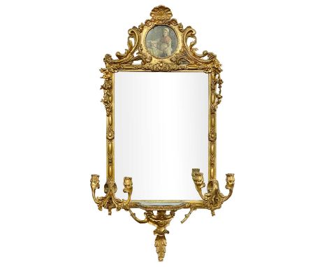 A  19th century continental gilt gesso wall mirror/girandole. The ornate scrolled crest with inset picture, the frame with fl