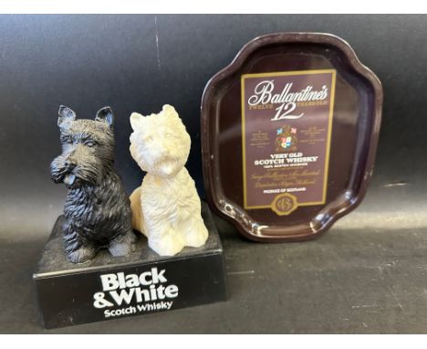 A Black and White Scotch Whisky plastic advertising figure plus a small Ballantine's whisky tin tray.