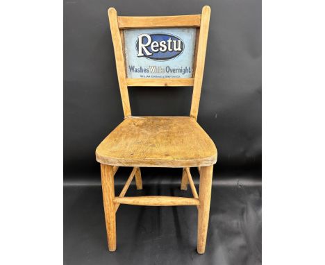 A wooden chair with inset enamel sign to the back, advertising Restu. 
