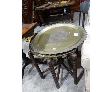 An Indian Brass Circular Occasional Table On A Folding Wooden Base, Together With A Further Circular Brass Tray