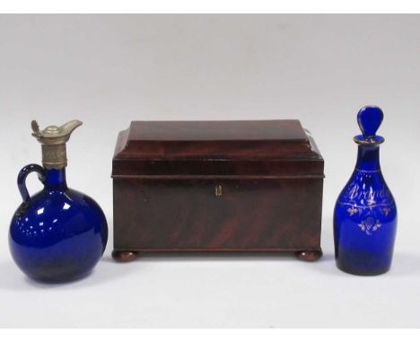 A 19th century mahogany tea caddy with three compartments, a blue glass brandy decanter with stopper and another blue glass d
