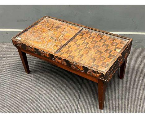 A low games table with the lift off top with carved panel depicting Daniel and the lions and a chess board, on an associated 