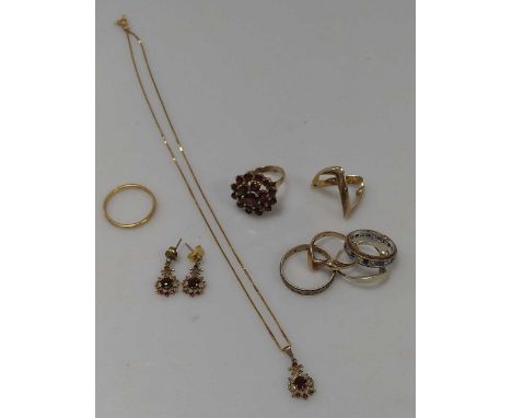 A hallmarked 22ct gold wedding band, weight 2.9g, together with a two plain hallmarked 9ct gold rings, a garnet ring stamped 