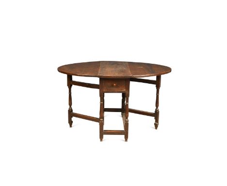 An elm and oak gate leg table, early 18th century, the oval drop flap top with two short end drawers on turned supports67.5 x