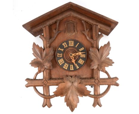Stained and carved wood cuckoo clock, traditional form, the movement striking on a gong, 46cm.