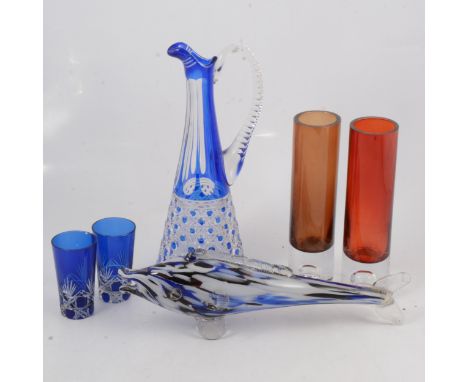A large blue overlaid glass lemonade jug with six tumblers; another set of tumblers; vases; Murano-style ruby glass camel; fi