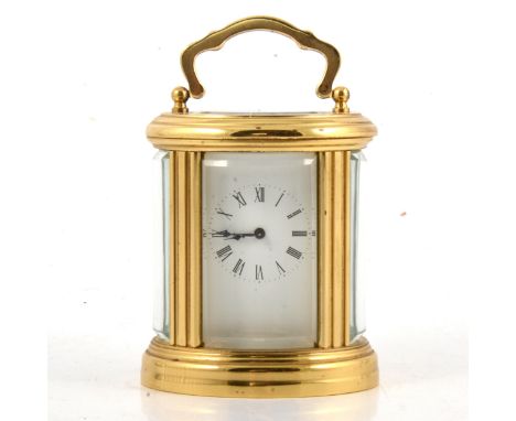 Small brass carriage clock, oval case, rectangular enamelled dial, height 8.5cm.