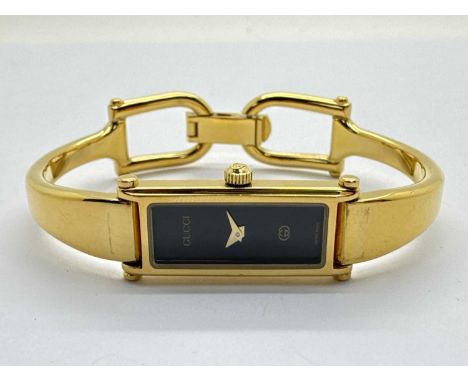 Gucci; A 1500L Gold Plated Ladies Wristwatch, with signed black rectangular dial.