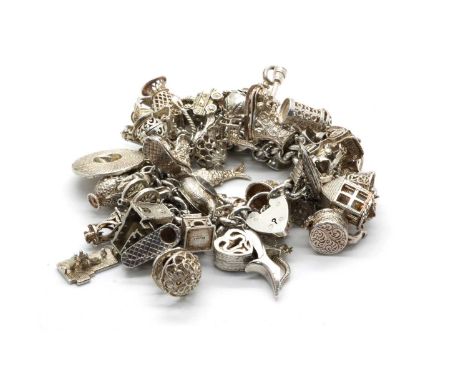 A Hallmarked Silver Chunky Curb Link Charm Bracelet, suspending a large quantity of assorted charms, including articulated ic