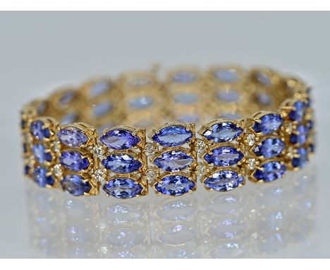 Breites Gliederarmband mit 51 Tansanit-Navetten, zus. ca. 22 ct, und 34 Brillanten, zus. ca. 1 ct, 21. Jh.585/- Gelbgold; Ges
