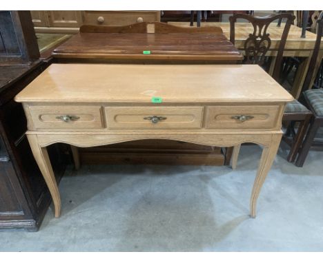 A light oak dressing table with three drawers