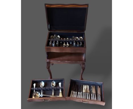 A silver plated canteen of flatware housed with a canteen cabinet 