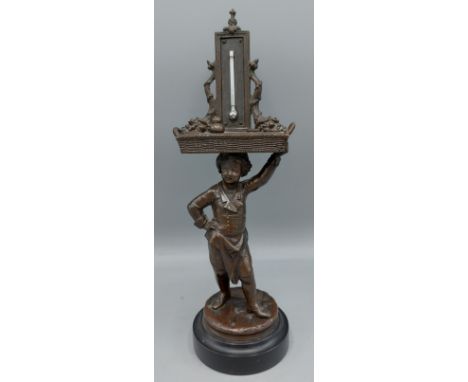 A Victorian bronze match striker/ thermometer of figural form with basket, 25cms tall