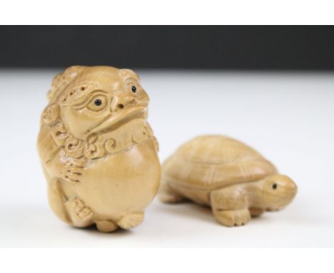 Two carved wooden netsuke in the form of a tortoise and a mythical beast. Measures 5cm and 6.5cm. 