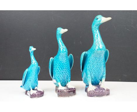 Set of 3 seated turquoise ceramic ducks in graduating size, 26cm tallest, 16cm smallest. 