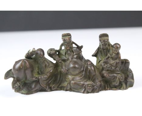 Small cast bronze Buddhist figure group. Measures 11cm wide. 