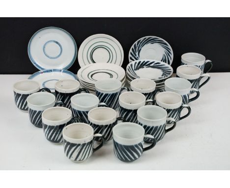 Studio art style hand painted ceramic coffee cups and saucers, including sixteen cups and sixteen saucers. 