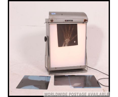 A fabulous mid century industrial enamel painted x-ray light box complete with an x-ray of a hand being ideal as a table lamp