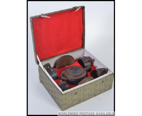 A cased mid century Chinese tea service for four, to include a KangXi teapot, four cups and saucers. All with character marks