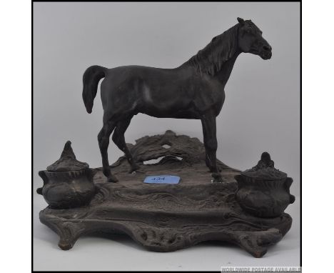 A cast bronze inkwell in the form of a horse on an ornate base with hinged inkwells, in the style of Mene 25cm