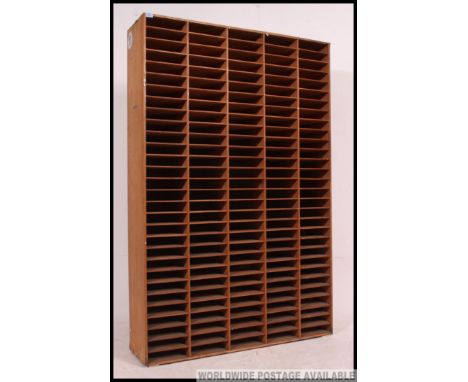 An  vintage / retro industrial office tall 150 hole pigeon hole unit for paperwork, five rows of thirty, being constructed en