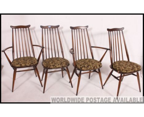 A set of 4 Ercol beech and elm wood dining chairs having panel seats with arched back rests,all raised on turned legs Measure