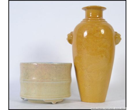 A  Chinese monochrome yellow vase adorned with fu-dog masks and incised decoration of dragons and clouds. The underside with 