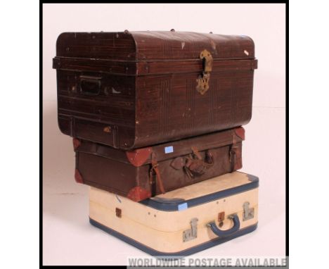 A vintage early 20th century tin tack trunk together with a leather suitcase and a two tone vinyl example