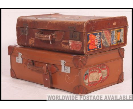 A near pair of vintage leather suitcases, with many original travel / shipping labels to include Cunard along with many hotel