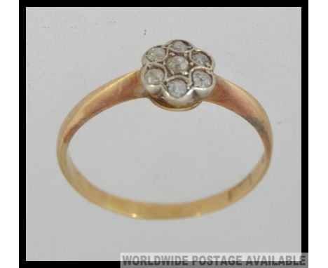 An 18ct gold and platinum vintage ladies diamond illusion flower head ring. The 5 stone setting with approx 12pnts of diamond