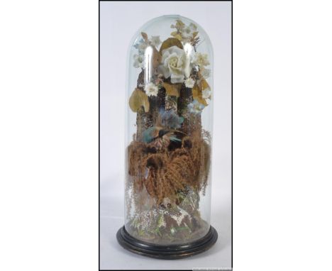 A 19th century Victorian taxidermy study of a Kingfisher (Alcedo atthis), set in a naturalistic setting of ceramic flowers, u