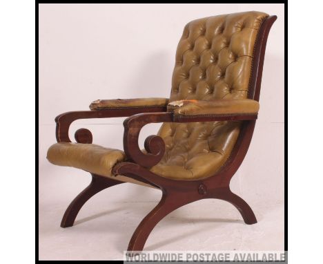 A mahogany and green leather chesterfield armchair. The green leather upholstered being button backed to the show wood frame