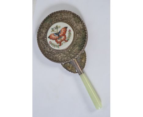 A vintage Chinese white metal, jade and porcelain mirror with hand painted butterfly to verso in a white metal filigree decor